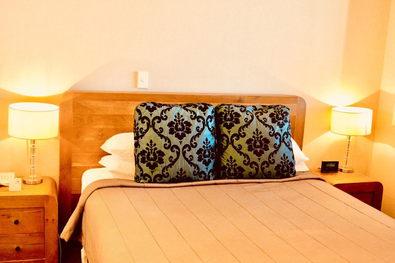โรงแรม เดอะ นอติลุส เนเปียร์ ภายนอก รูปภาพ A bed with a decorative pillow